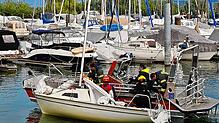Die Radolfzeller Feuerwehr schleppt das gekenterte Segelboot an und bringt es zurück in den Hafen.