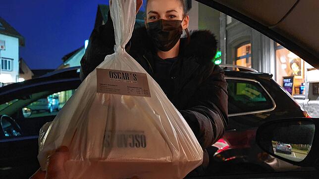 Die nette Bedienung des Oscar&lsquo;s überreicht das Essen durch die Autotür.