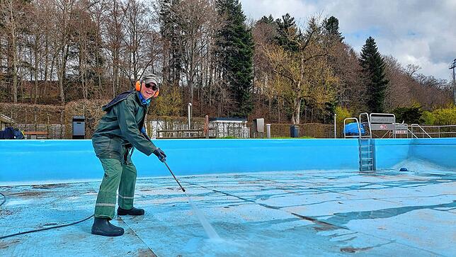 Walter Schramm macht das Nichtschwimmerbecken mit dem Hochdruckreiniger sauber. Zersetztes Laub hat auf dem Boden seine Spuren hinterlassen.