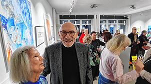 Ausstellungsorganisator Hans Kunz mit der Überlinger Künstlerin Margit Vischer-King. Im Hintergrund eines ihrer Werke in Blau. Bild: ...