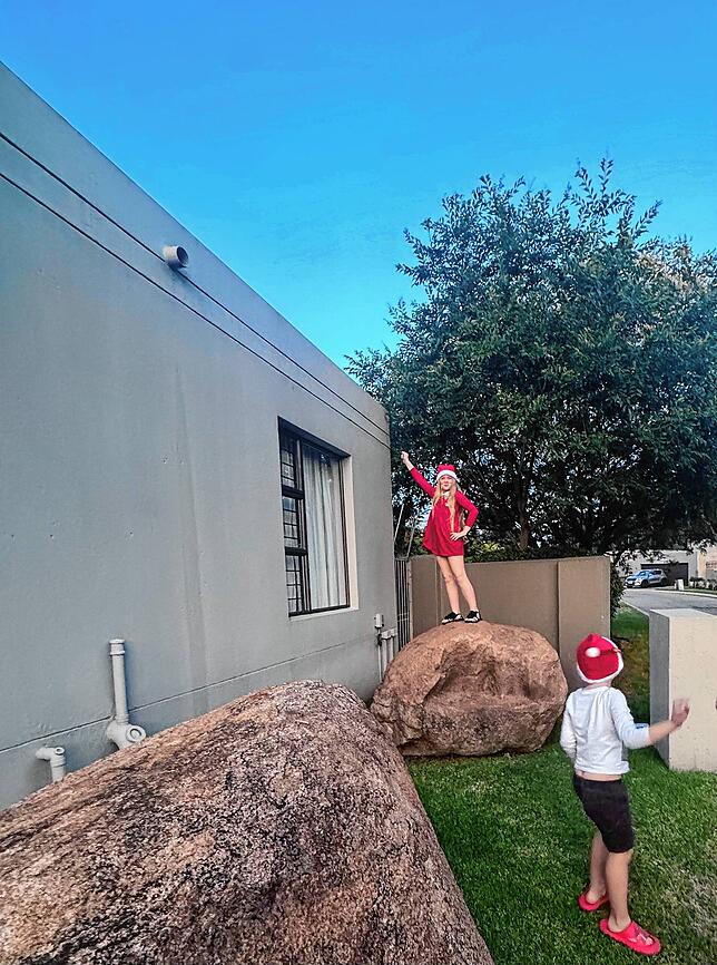 Lenn und Juna Regniet spielen als Nikoläuse verkleidet vor dem Haus in Südafrika.