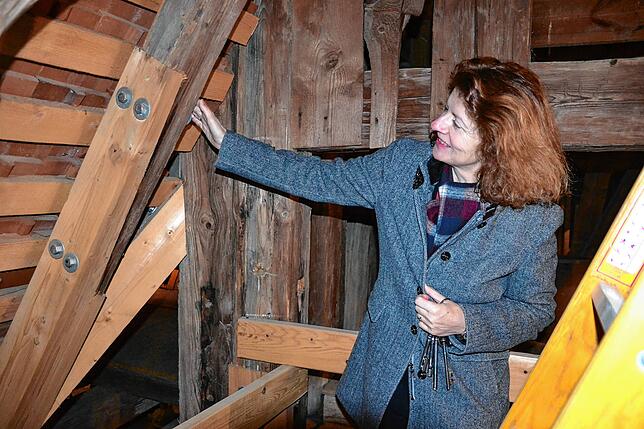 Schlossverwalterin Birgit Rückert zeigt auf eine ausgebesserte Stelle im Dachstuhl. Die morschen Teile der Balken wurden herausgenommen ...