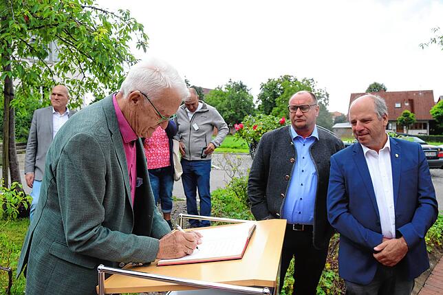 Der Ministerpräsident (links) trägt sich ins Goldene Buch der Gemeinde ein. Rechts daneben stehen die beiden Landtagsabgeordneten Klaus ...