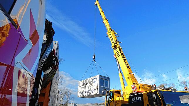 Der Autokran hebt die Container, die den Jugendraum in Jestetten gebildet haben, auf die Lastwagen. Bild:  Rotraud Opfermann