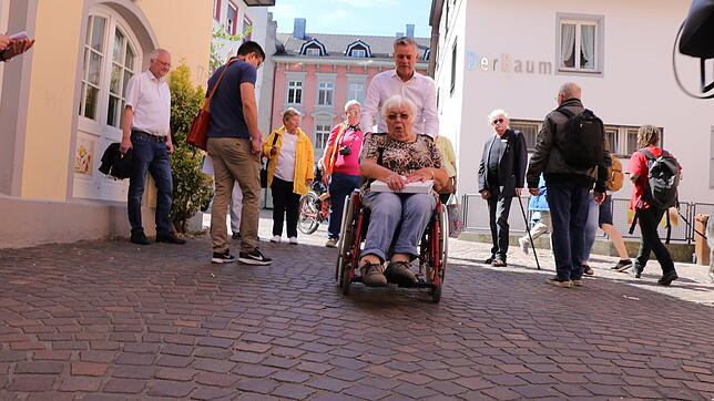 Der Rollstuhl läuft leichter übers Kopfsteinpflaster mit den aufgefüllten Fugen: Tiefbauamtsleiter Uwe Negrassus testet zusammen mit ...