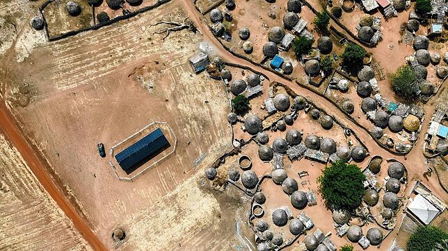Container mit Solarzellen und im Inneren mit Batteriespeichersystemen ausgestattet (im Bild links) liefern einer Siedlung in Afrika ...