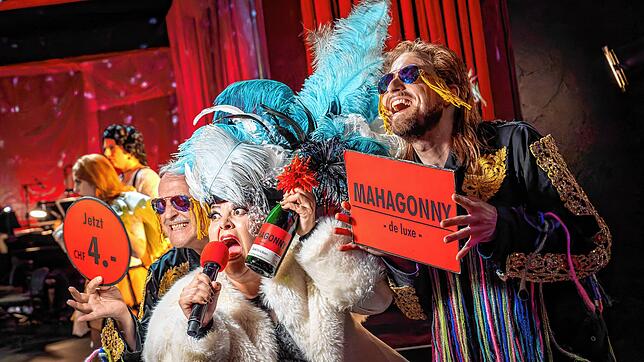 An Schampus besteht kein Mangel in der Konsumstadt Mahagonny. Die geschäftstüchtige Frau Begbick preist ihn zum Sonderpreis an.