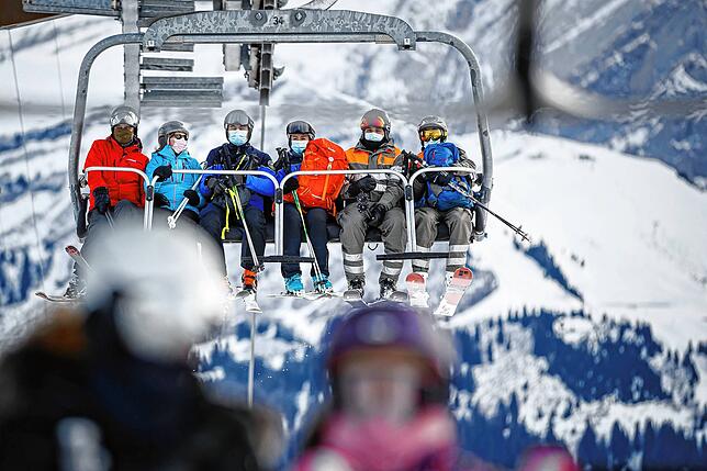 Gäste im Sessellift i Schweizer Skigebiet von Villars-Sur-Ollon. Werden Betriebszeiten eingeschränkt?