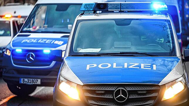 Polizeiautos mit eingeschalteten Scheinwerfern und Blaulicht. (Symbolbild)
