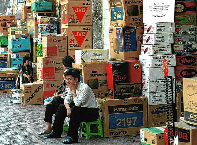 Verkäufer warten 1998 in Hanoi vor ihren Waren auf Kunden.