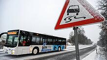 Ein Schulbus fährt auf einer mit Schnee bedeckten Straße (Archivbild). Im südlichen baden-Württemberg ist es wegen Glatteis zu vielen ...