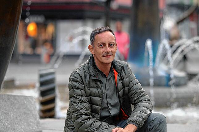Tom Lendzian am Brunnen auf dem Adenauerplatz, auf dem am Sonntag die Queer Pride-Kundgebung starten wird.