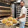 Robert Schorp holt in seiner Bäckerei in Döggingen die fertigen Brote aus dem Ofen.