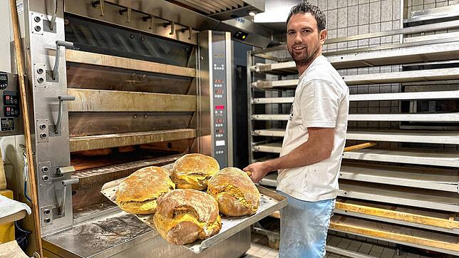 Robert Schorp holt in seiner Bäckerei in Döggingen die fertigen Brote aus dem Ofen.