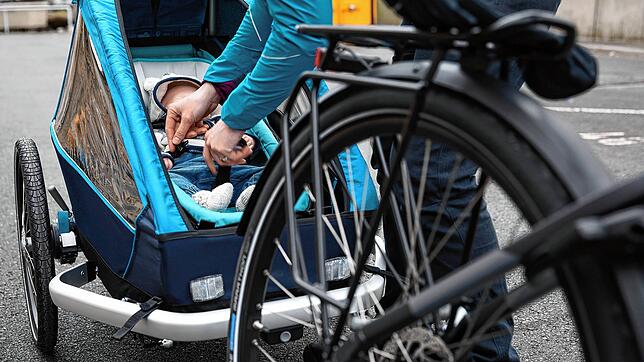 Ein Fahrrad mit Anhänger und Baby. (Symbolbild) So ein Hänger mit einem Baby drin hat sich bei einem Unfall bei Rheinfelden überschlagen.