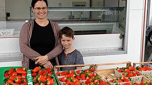 Stefanie und Matheo Stoll trotzen dem Regen und verkaufen am Erdbeerstand in Kadelburg die riesigen Erdbeeren der sogenannten Königsblüte.