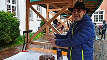 Marktbesucher Johannes Wiedmann prüft, ob man sich am dekorativen Feuerwirbel auch die Hände wärmen kann.