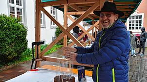 Marktbesucher Johannes Wiedmann prüft, ob man sich am dekorativen Feuerwirbel auch die Hände wärmen kann.