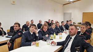 Die Feuerwehrmänner und -frauen verfolgen bei der Hauptversammlung im Feuerwehrgerätehaus den Jahresbericht von Abteilungskommandant ...