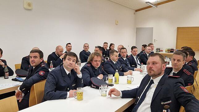 Die Feuerwehrmänner und -frauen verfolgen bei der Hauptversammlung im Feuerwehrgerätehaus den Jahresbericht von Abteilungskommandant ...