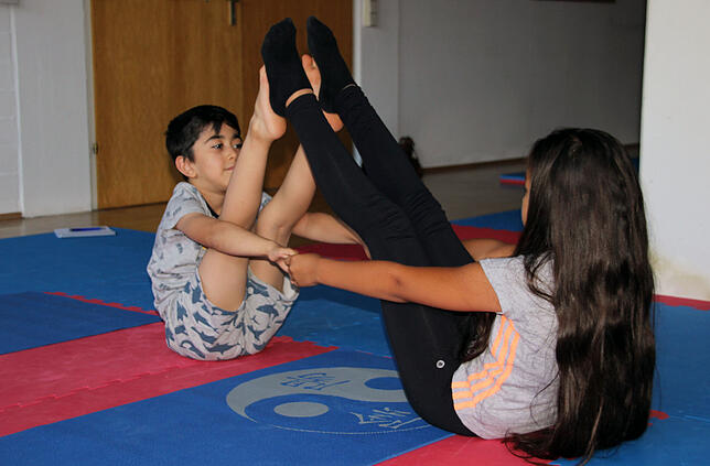 Eyez (7) und Shaylo (10) bei der Yoga-Partnerübung „Das Zelt“. Bei diesem Asana sind ein guter Gleichgewichtssinn, ...