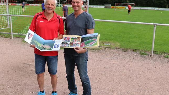 Charly Strauß und Olaf Thor freuen sich über ein perfektes Erinnerungsalbum über den Sportplatzumbau. Die ersten Wermutstropfen gibt es ...