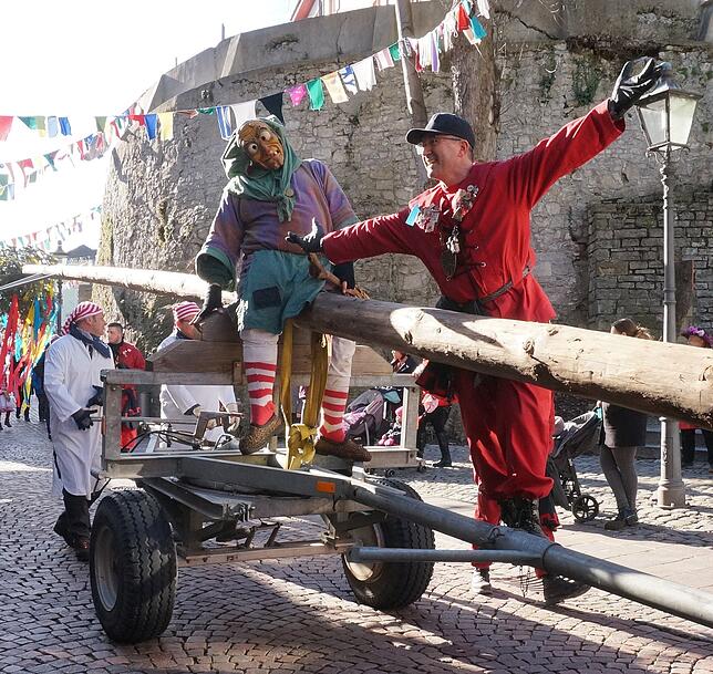 Lang und schlank: Viele Meter lang ist der Narrenbaum, der inmitten des Kinderumzug mit schwerem Gerät zum Marktplatz transportiert ...