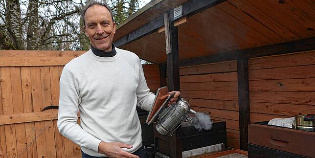 Martin Schröpel, Vorsitzender des Imkervereins Konstanz, beruhigt seine Bienen mit Rauch, damit er den Bienenstock ungestörter öffnen kann.