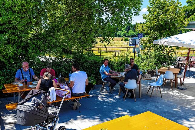 Gäste genießen auf der Zollhäusle-Terrasse das Sommerwetter.