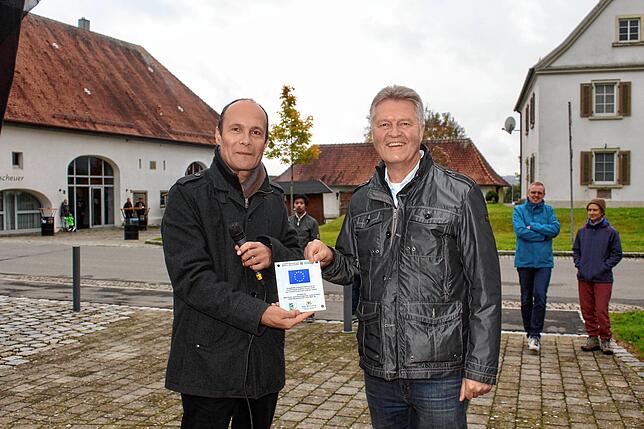 Riedhausens Bürgermeister Ekkehard Stettner (rechts) erhält von Bürgermeister Christoph Schulz die Leader-Plakette, einem ...