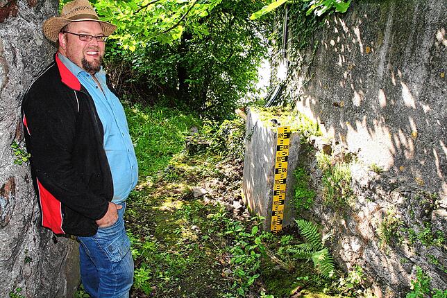 Roland Schleicher an einer von fünf Pegellatten hinter der Pegelanlage. Sie dienen der optischen Kontrolle.
