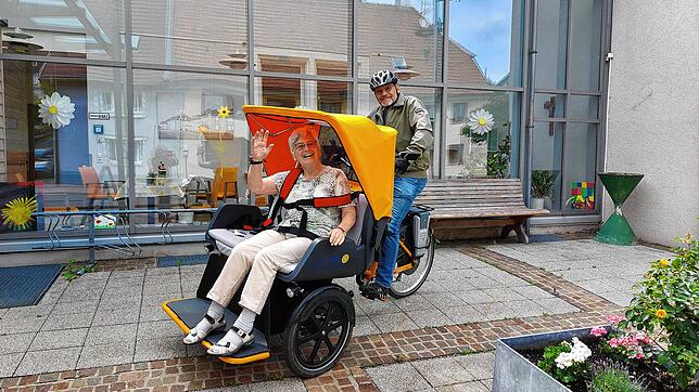 Nelly Bloszat (87) sitzt angeschnallt in der Rikscha, Helmut Kienzle fährt. Foto: Ingo Günther
