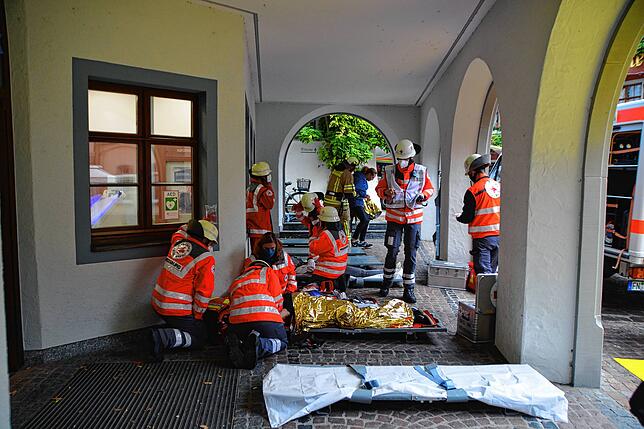 Unter dem schützenden Dach der Bankfiliale versorgen die Einsatzkräfte des Deutschen Roten Kreuz die Verletzten.