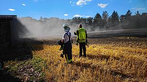 Zwei Einsatzkräfte der Feuerwehr vor dem brennenden Feld beim Buchhof in Möggingen. Bei heißen Temperaturen und viel Wind war es keine ...
