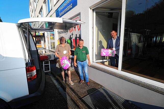 Hier wird ein Kastenwagen unter anderem mit Toilettenpapier für den Transport beladen (von links): Tanzschulleiter und Koordinator ...