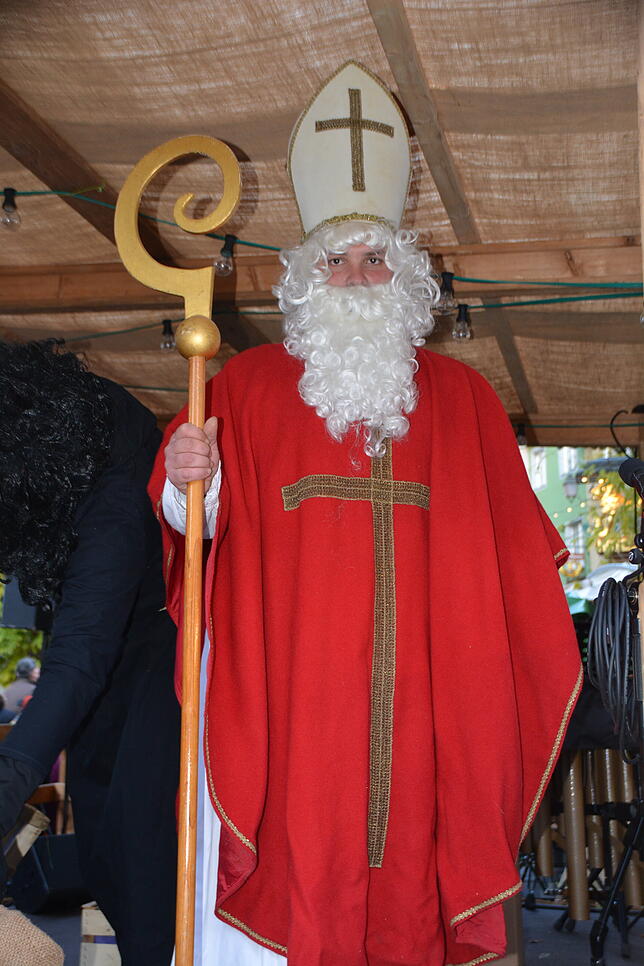 Der Stadtnikolaus und Knecht Ruprecht verteilen Tüten mit weihnachtlichen Leckereien an die Kinder.