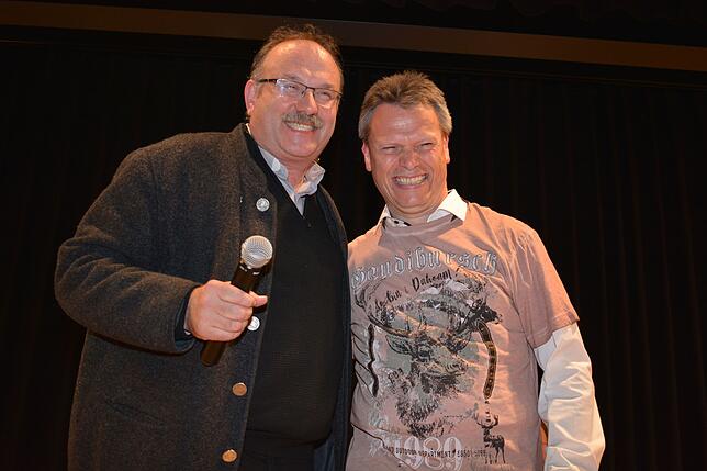 Der katholische Stadtpfarrer Matthias Schneider (links) schenkt Frank zum Jubiläum ein „Gaudibursch“-T-Shirt.