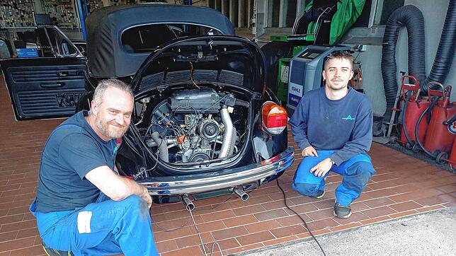 Patrick Münzer (links) und Jannick Hofheinz haben eine Auspuffprüfanlage an ein Fahrzeug angeschlossen. Foto: Dietmar Zschäbitz