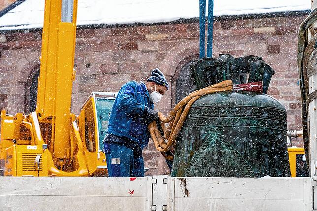 Dichtes Schneetreiben herrscht, als die Glocke mit Spezialseilen am Kran befestigt wird.