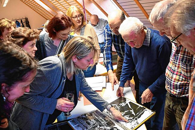 Die Zizenausener blättern die Alben durch und unterhalten sich angeregt zu den Motiven.