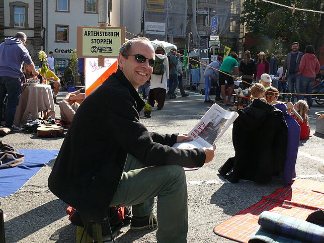 Oliver Trevisiol liest demonstrativ die Zeitung auf dem Stephansplatz – das scheint ihm allemal geeigneter als Autos dort zu parken.