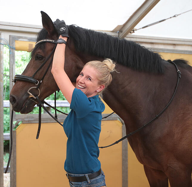 Jessica von Bredow-Werndl legt die Trense an. Bild: Roger Müller
