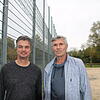 Am Zaun des Kunstrasenplatzes auf der Mettnau stehen Michael Jentsch (links) und Axel Tabertshofer von der IG Sport. Im Hintergrund soll ...