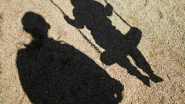 Der Schatten von einem Mann und einem schaukelnden Kind. Beim Thema Missbrauch sind viele Erwachsene unsicher. (Symbolbild)