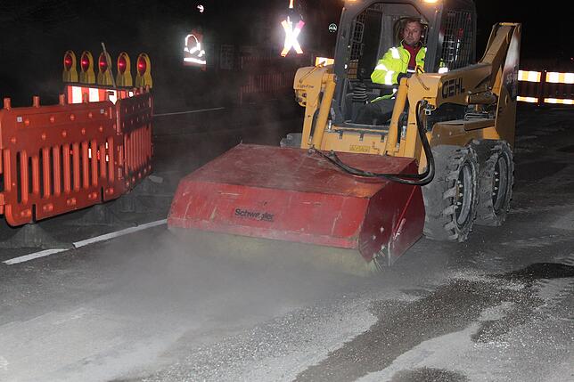 Nachdem Ion Stanciu die Markierungen abgefräst hat, säubert er die Fahrbahn mittels Walzenbürste.