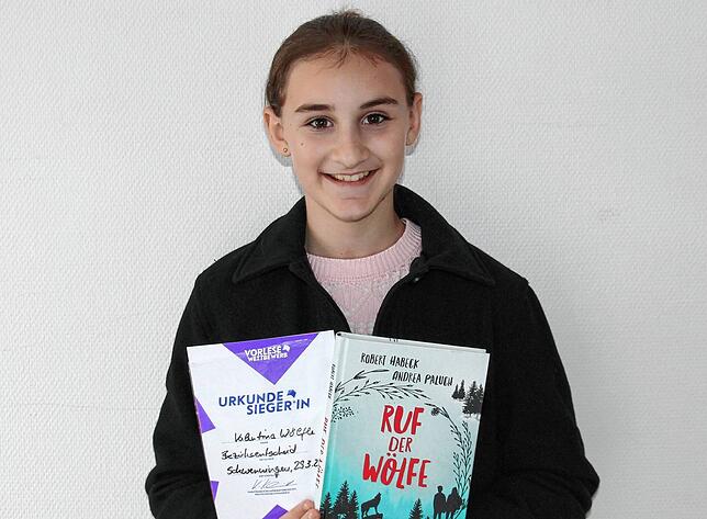 Valentina Wölfle präsentiert die Siegerurkunde sowie das als Preis erhaltene Buch vom Bezirksentscheid Ende März.