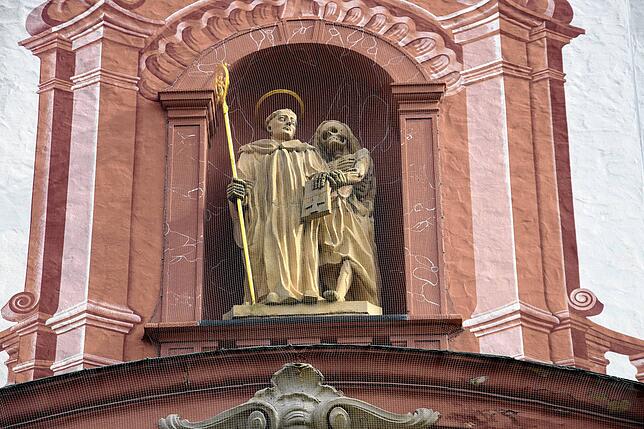 Weit oben im Portal des Bad Säckinger St. Fridolinmünsters wacht der Heilige Fridolin mit dem von ihm auferweckten Urso aus Glarus am ...