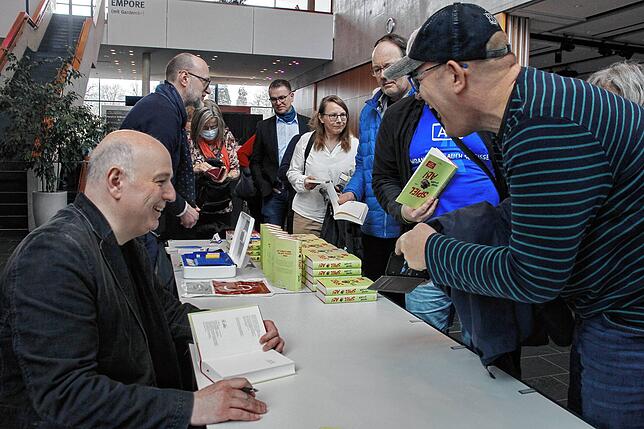 Fröhliche Stimmung auch nach der Lesung: Frank Goosen (links) beim Signieren seines neuen Buches „Spiel ab!“, in dem er ...