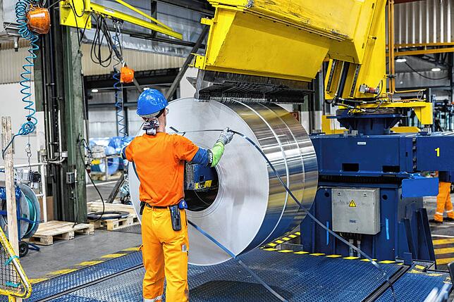 Ein Mitarbeiter des Walzwerks bindet eine Aluminium-Coil ab.