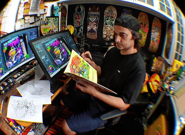 Cartoon-Artist und Helloween-Illustrator Marcos Moura prüft an seinem Arbeitsplatz in Sao Paulo den fertigen Druck des illustrierten ...